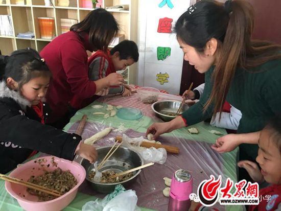 家长们和队员们一起包饺子